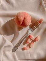 Peach slices and a fork on a beige cloth. Toned. photo