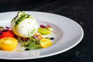 Salad with mozzarella cheese, tomatoes and herbs on a white plate photo