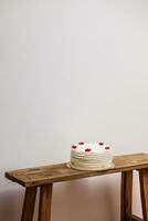 Cake on a wooden table against a white wall. Vertical. photo