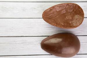 Chocolate Easter eggs on white wooden background. Top view with copy space photo