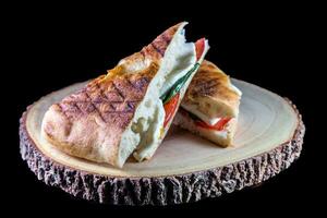 Sandwich with ham, cheese and vegetables on a black background. photo