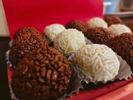 Chocolate truffles on red background. Selective focus. photo