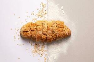 Loaf of bread with cereals on white background, top view photo
