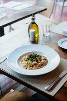 Risotto with black beans on a wooden table in a restaurant photo