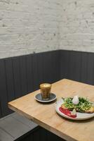 Coffee and salad on a wooden table in a cafe. photo