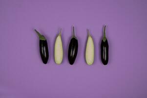 Eggplant on purple background. Flat lay, top view. photo