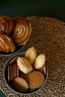 Cinnamon buns and cookies on a dark background, selective focus photo