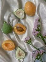 Apricot and figs on a white cloth with flowers. photo