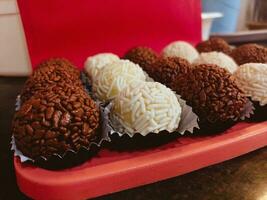 Chocolate truffles on a red tray. Selective focus. photo