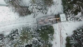 aérien Haut vue de une grue un camion en essayant à tour autour sur étroit hiver route. agrafe. véhicule et et hiver neige couvert des arbres. video