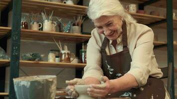 ceramica arte, anziano donna, anziano età, creativo tempo libero. senor donna fa un' ciotola durante ceramica. video