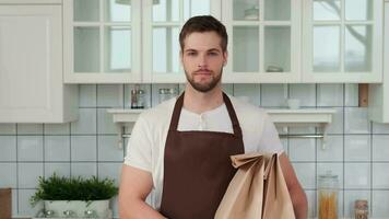 vegano culinária, masculino chefe de cozinha, saudável comendo, Comida Entrega. homem detém Comida pacotes dentro dele mãos depois de Entrega video