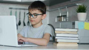 in linea apprendimento, distanza lezione, formazione scolastica a casa, tecnologia per bambini. ragazzo con libri di testo fare scuola compiti a casa e utilizzando digitale tavoletta computer a casa. 4k video