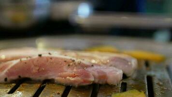 selective focus view to the pork meat while being grilled on the traditional korean charcoal pan stove called Galbi. video