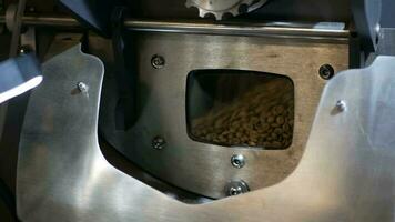 POV view of aromatic brown coffee beans while roasting through small checking window on the Coffee roaster machine video