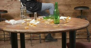 Dirty restaurant floor and table after a busy day. Waiters in the background relaxing and chatting. video