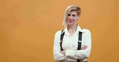 Portrait of stylish blonde woman smiling at the camera. Cute woman with stylish hairstyle on yellow background. video