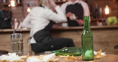 vacío cerveza botella en un sucio mesa en un cerrado bar. Clásico estilo restaurante. empleados relajante antes de clausura y limpieza. video