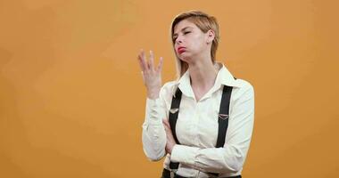 Young woman looks very confused then gets a good idea and is happy about it. Contemplative women over yellow background. video