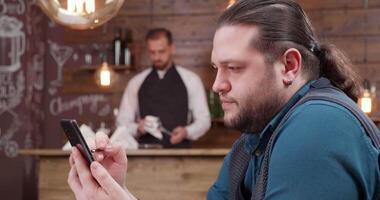 criativo homem usando dele caneta em a tela do a Smartphone. desenhando esboços durante café pausa dentro uma pequeno caf . caligrafia em Smartphone. video