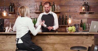 servitris på en bar disken passionerat talande en berättelse till de bartender. anställda njuter en ha sönder. video