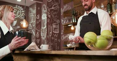 Loiras bonita garçonete fala para dela masculino colega. dizendo histórias durante uma pausa. restaurante trabalhadores relaxar. video