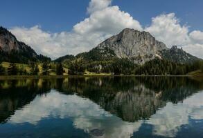 view to a nature landscape with reflections in a mountain lake named wurzeralm  in austria photo