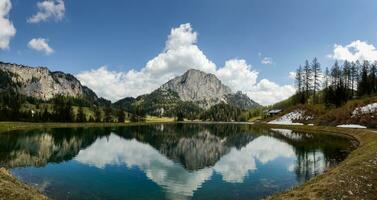 incredible view to a nature landscape with reflections in a mountain lake named wurzeralm in austria panorama photo