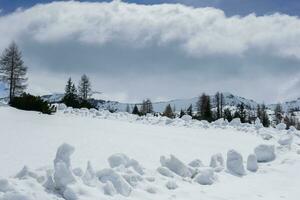 snowy mountain landscape with a huge white cloud at the sky photo