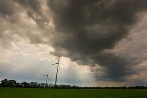 dense dark rain clouds and pinwheels on a field photo