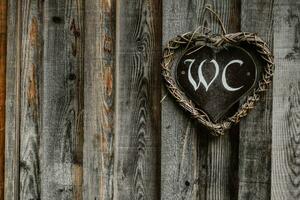 handmade sign for toilet on a wooden door in the nature photo