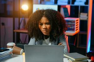 Business woman drinking coffee to get some energy for working overtime sitting at desk using computer and doing overtime photo