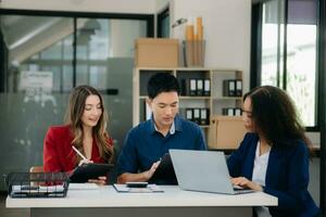 Office colleagues have a casual discussion. During a meeting in a conference room, a group of business teem sit in the conference room photo