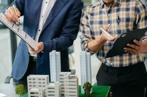 balancing the property sector The real estate agent is explaining the house style to see the house design and the purchase agreement. house city photo