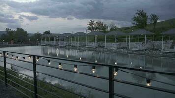 a lake with a fence and umbrellas in the background video