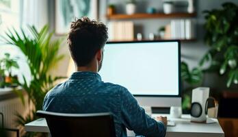 AI generated Over shoulder shot of a young man using computer in front of an blank white computer screen in home photo