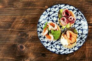 Tartlets or canapes with fish, shrimp and bacon. photo