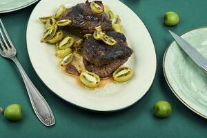 Grilled ostrich steak with kiwi berries photo