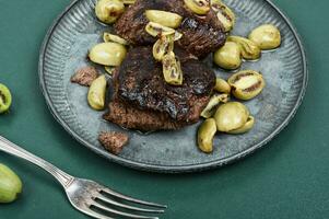 Grilled ostrich steak with kiwi berries photo