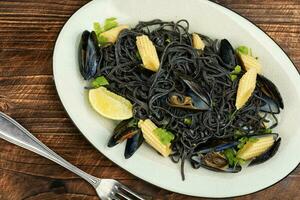 Black spaghetti pasta with mussels. photo