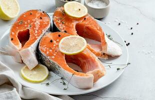 Stake Fish trout with lemon and spices on cement background photo