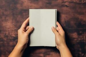 AI generated Woman holding book with blank cover on brown background, top view. AI Generated photo