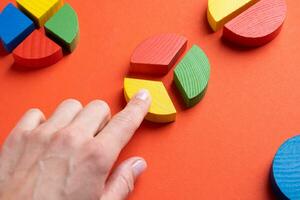 hands working with colorful wooden pie chart pieces photo