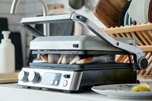 fresh trout steak ready being cooked on electric grill in the kitchen photo