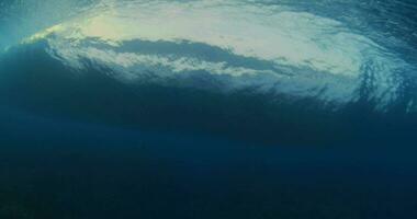 Underwater view of the barrel wave breaking in tropical blue ocean video