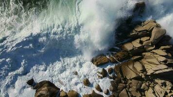 lento movimento dall'alto al basso Visualizza di potente tempesta onde rotolamento su il roccioso riva video