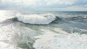 Powerful waves forming, breaking on the shore and splashing with white foam video