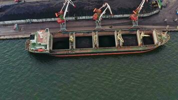 masse transporteur est chargé avec charbon dans le Port en utilisant grues. drone vue video