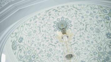 Decorative ceiling in a form of a dome with blue floral pattern. Scene. Hanging small chandelier, bottom view. video