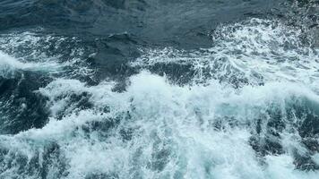 hermosa olas desde Moviente bote. acortar. salpicaduras de olas desde Moviente mar bote. hermosa olas Moviente oblicuo desde flotante barco en mar video